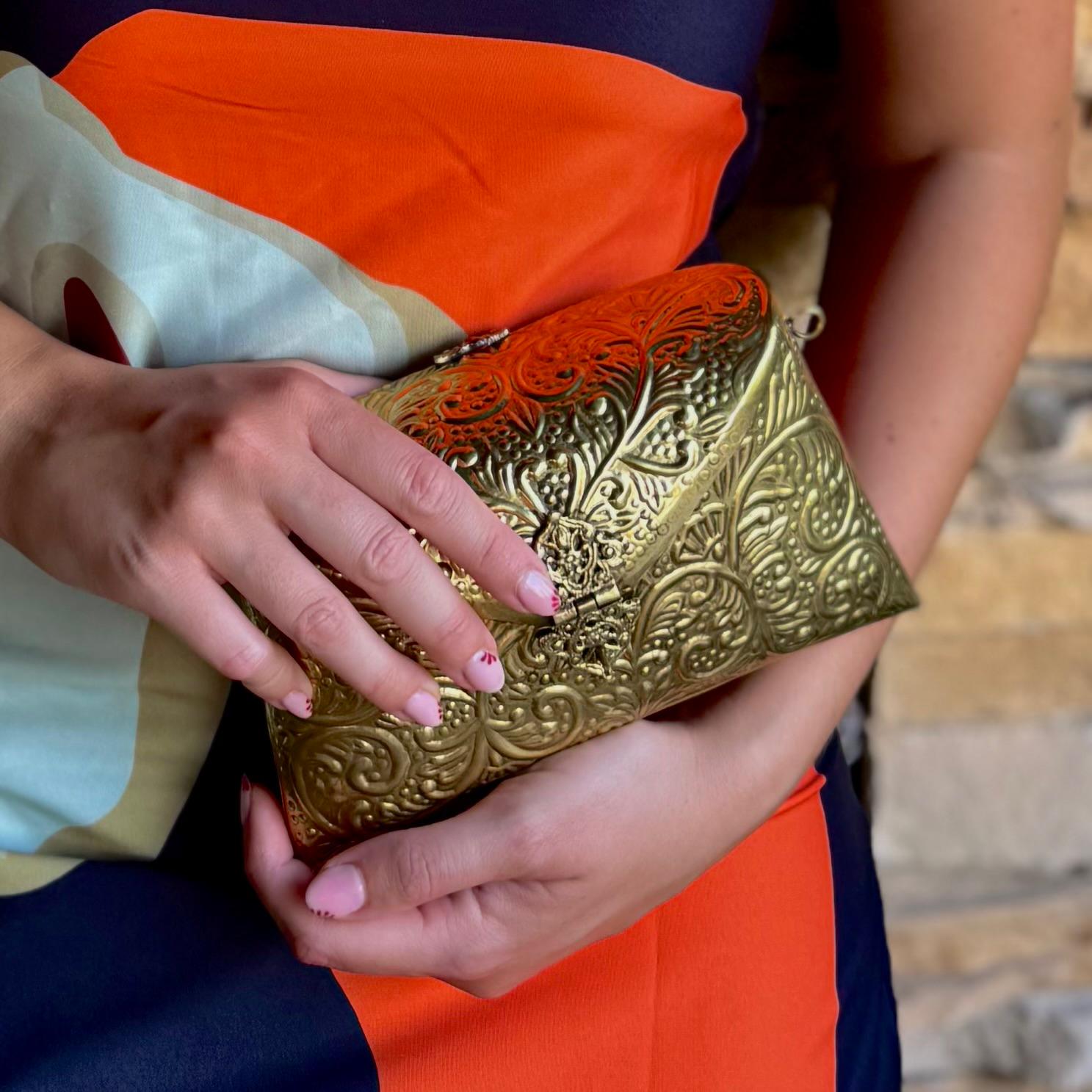 Bolso de fiesta artesanal en latón dorado con cadena interior. Diseño elegante de 16×11 cm, con capacidad para el móvil. Pieza única hecha a mano, perfecta para bodas, fiestas y eventos especiales.